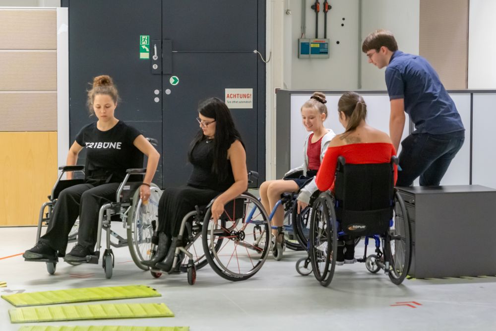 Vier Frauen in Rollstühlen, die einen Parcour absolvieren