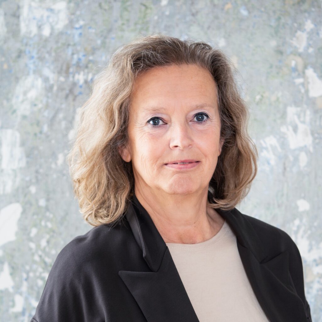 Antonia Mattersberger hat blonde gelockte schulterlange Haare. Sie ist zwischen 50 und 60 Jahre alt und hat blaue Augen.